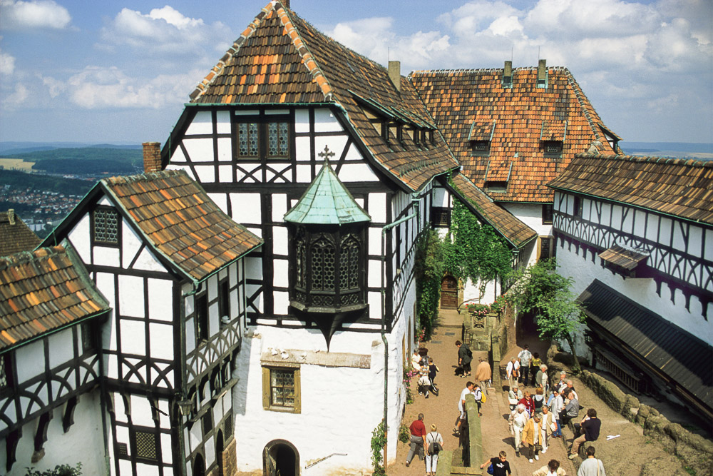 The Nuremberg bay window was installed in the 19th century, in the gable end of the so-called Vogtei (“bailiwick”) at Wartburg Castle. The window features a wood frame with four crown glass panes. A steep path to the right of the building leads to a second courtyard.