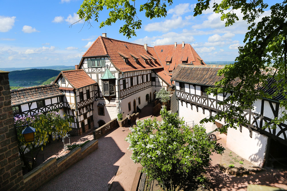 Der Blick in den ersten Burghof, den sogenannten Vorhof der Wartburg, zeigt die Vogtei, die sich im Norden der Burg befindet. In diesem Gebäude ist im Obergeschoss der authentische Arbeitsplatz Martin Luthers: die Lutherstube zu finden.